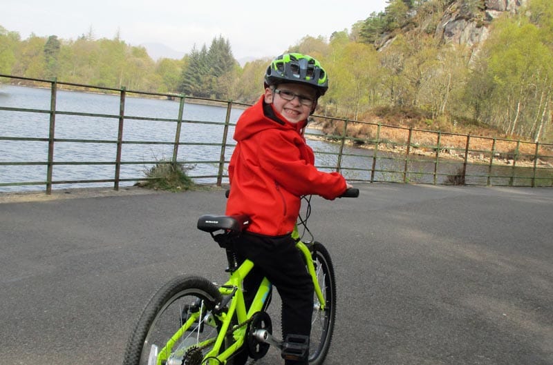 young boy on a green bike