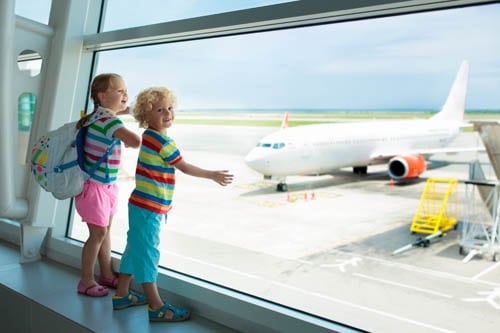 Kids at airport. Children look at airplane. Traveling and flying with child. Family at departure gate. Vacation and travel with young kid. Boy and girl before flight in terminal. Kids fly a plane.