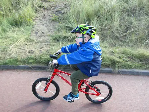 Young child cycling his red bike