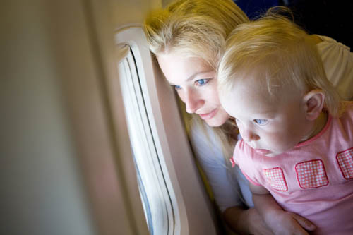 mother and child look through the window of the airplane