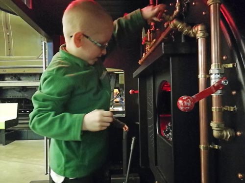 Young boy playing with the train controls