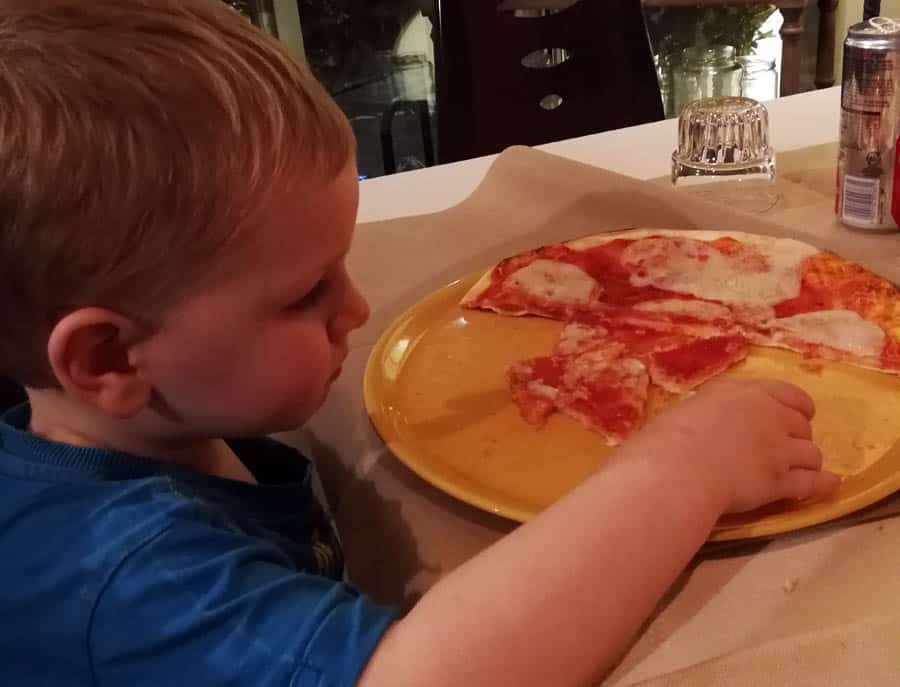 young boy eating pizza