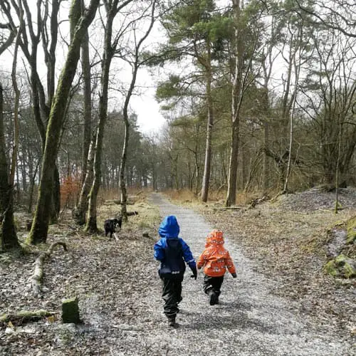 Two brothers running along a forest track