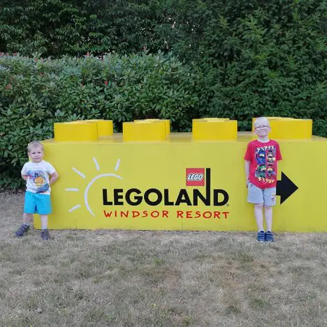 Two brothers standing at the Legoland Windsor sign