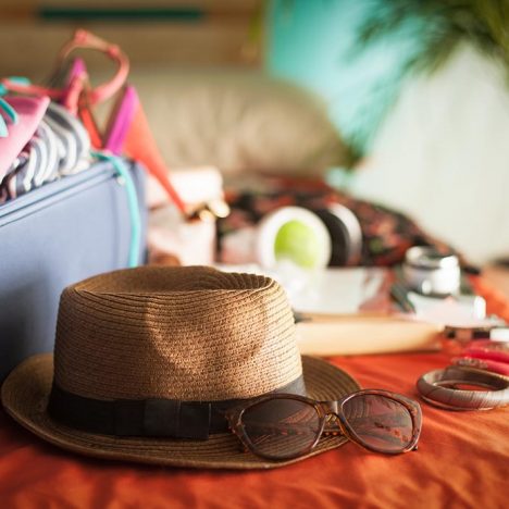 Woman's bedroom full of things ready to be taken on summer holiday.