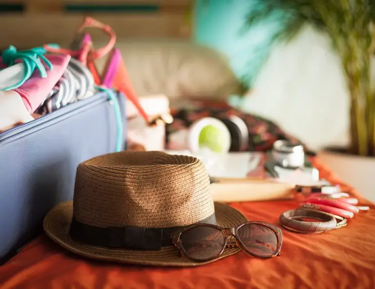 Woman's bedroom full of things ready to be taken on summer holiday.