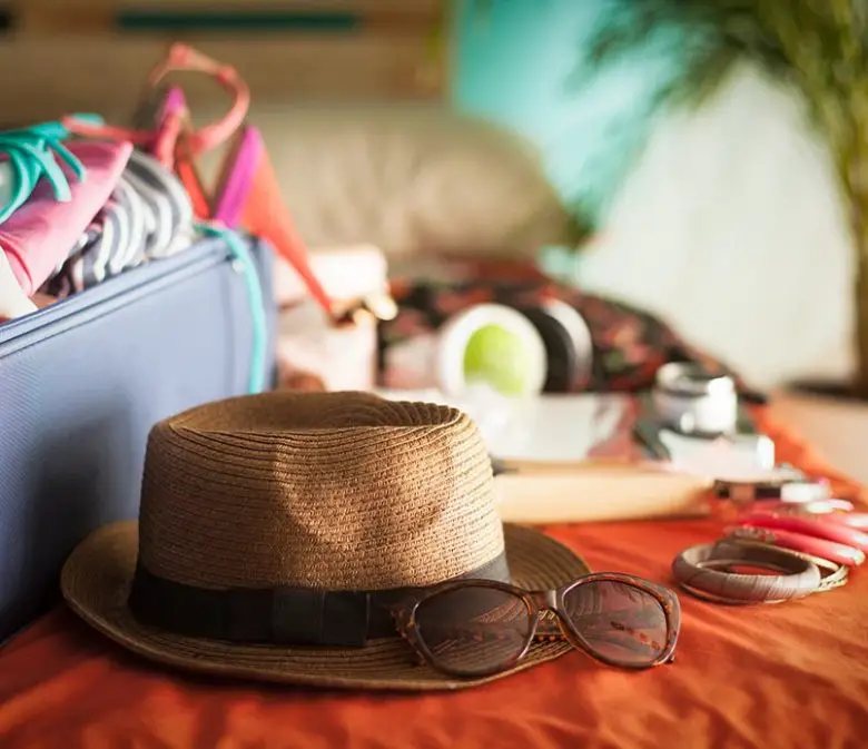 Woman's bedroom full of things ready to be taken on summer holiday.