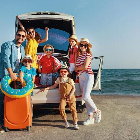 happy large family mother father and children in summer auto journey travel by car on beach