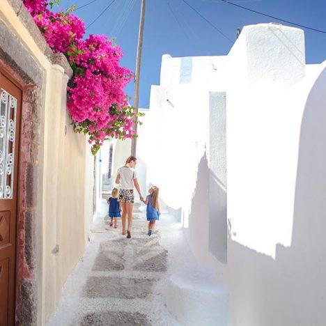 Beautiful cobbled streets with walking family on the old traditional White House in Emporio Santorini, Greece