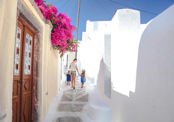 Beautiful cobbled streets with walking family on the old traditional White House in Emporio Santorini, Greece