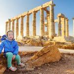 Cute young girl exploring the Ancient Greek temple of Poseidon at Cape Sounion, one of the major monuments of the Golden Age of Athens.