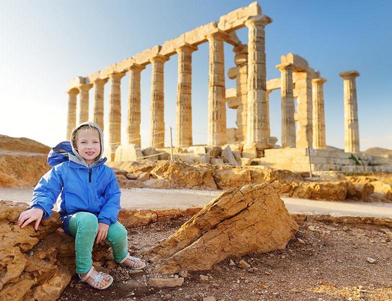 Cute young girl exploring the Ancient Greek temple of Poseidon at Cape Sounion, one of the major monuments of the Golden Age of Athens.